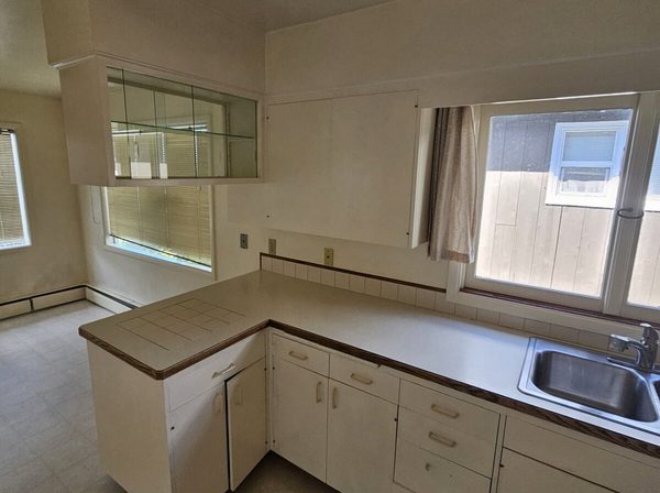 Dated kitchen cabinets before refinishing, yellowed cream doors