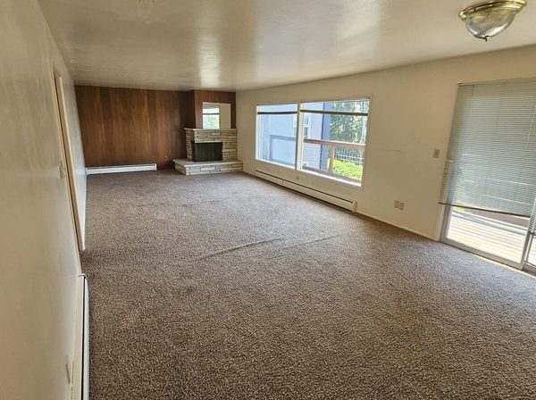 Living room before painting, dark wood panelled wall and stained ceiling