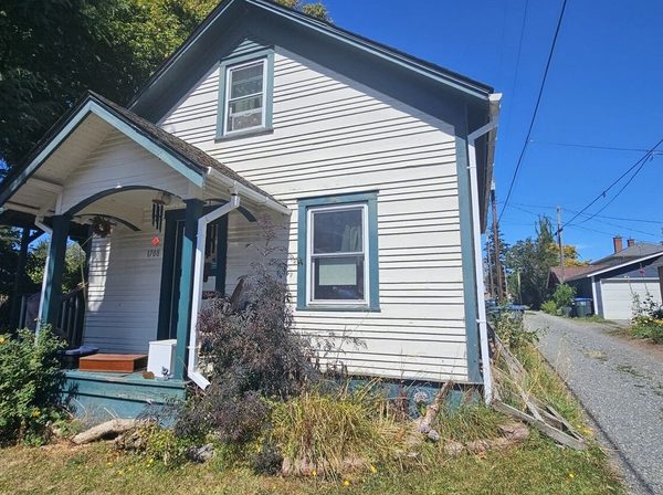Heritage cottage exterior before repainting, chalky peeling siding